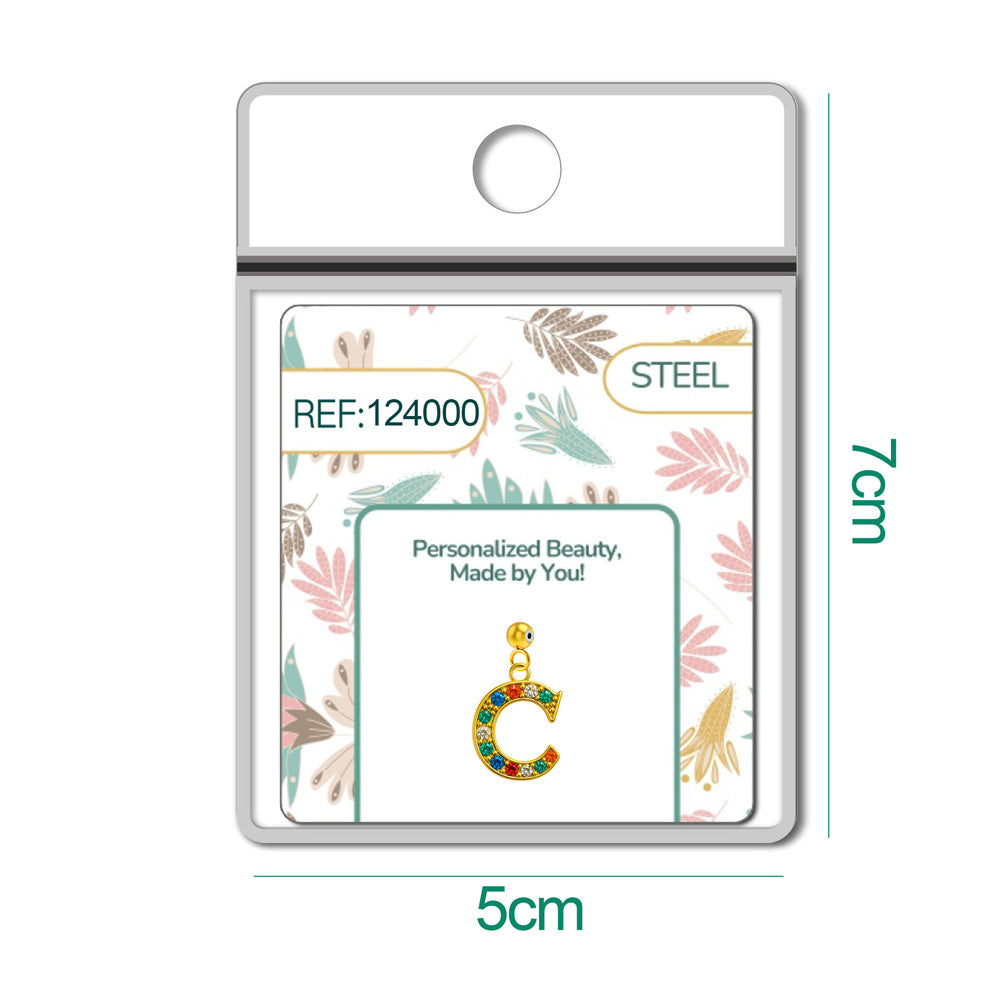 Detalle de charm colgante de letra C con detalle de circonita, acabado dorado y bola de acero con goma