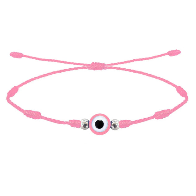 Pulsera rosa de 7 nudos con amuleto central de ojo turco rosa y cuentas plateadas en cordón ajustable.