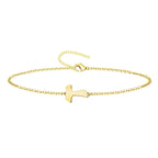 Pulsera de cadena fina con cruz Tau central en acero inoxidable de color dorado, acabado brillante y cierre ajustable de mosquetón.