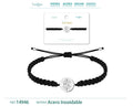 Pulsera de hilo negro trenzado con amuleto redondo de ojo turco calado y radiante en acero inoxidable plateado y cierre ajustable.