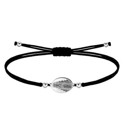 Pulsera de hilo encerado negro con medalla ovalada de la Virgen del Rocío en acero plateado y cuentas laterales