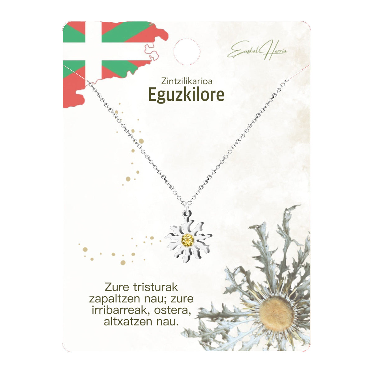 Collar de acero inoxidable plateado con colgante de Eguzkilore (Flor del Sol vasca) y cristal amarillo en el centro. Incluye tarjeta de regalo con la bandera del País Vasco (Ikurriña) y poema.