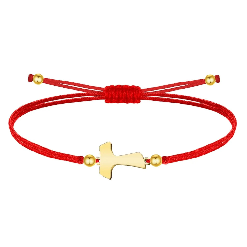 Pulsera de hilo rojo liso con cruz Tau central en acero dorado, esferas decorativas doradas y cierre ajustable.