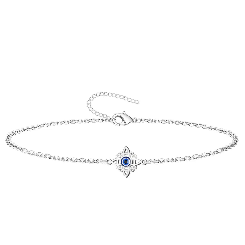 Pulsera de cadena fina en acero inoxidable plateado con charm del Nudo de Bruja y detalle central de Ojo Turco azul, amuleto de protección elegante.