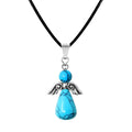 Colgante con forma de ángel hecho con cuentas de piedra turquesa y alas de metal plateado, montado sobre cordón negro.