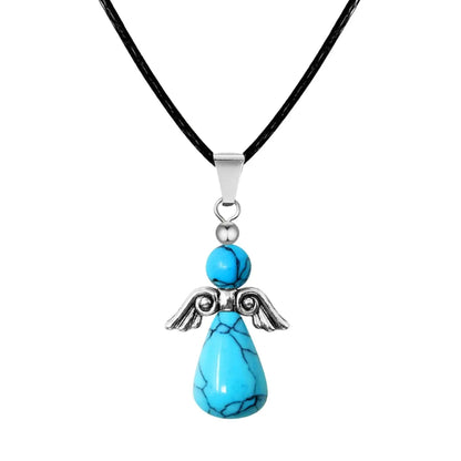 Colgante con forma de ángel hecho con cuentas de piedra turquesa y alas de metal plateado, montado sobre cordón negro.
