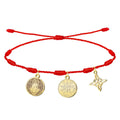 Pulsera de hilo rojo de 7 nudos con tres amuletos de acero inoxidable dorado: Medalla de San Benito (izquierda), Tetragrammatón (centro) y Nudo de Bruja (derecha).