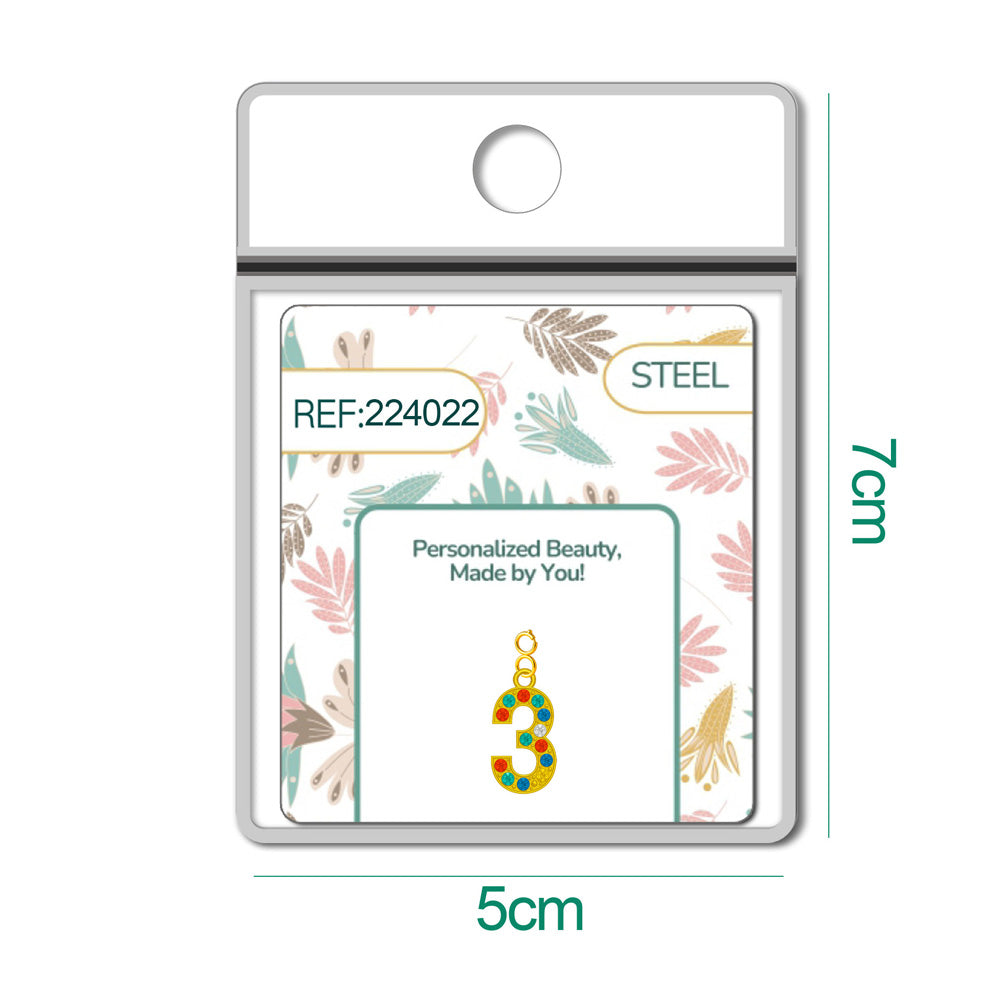 Charm dorado de número 3 con circonitas de colores con cierre de acero, en blíster