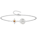 Pulsera de acero plateado con cadena de eslabones, destacando un Nudo de Bruja con piedra ojo de tigre marrón dorada en el centro y una medalla del Tetragrammatón.