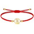 Pulsera de hilo con Virgen de Valvanera en acero y acabado dorado