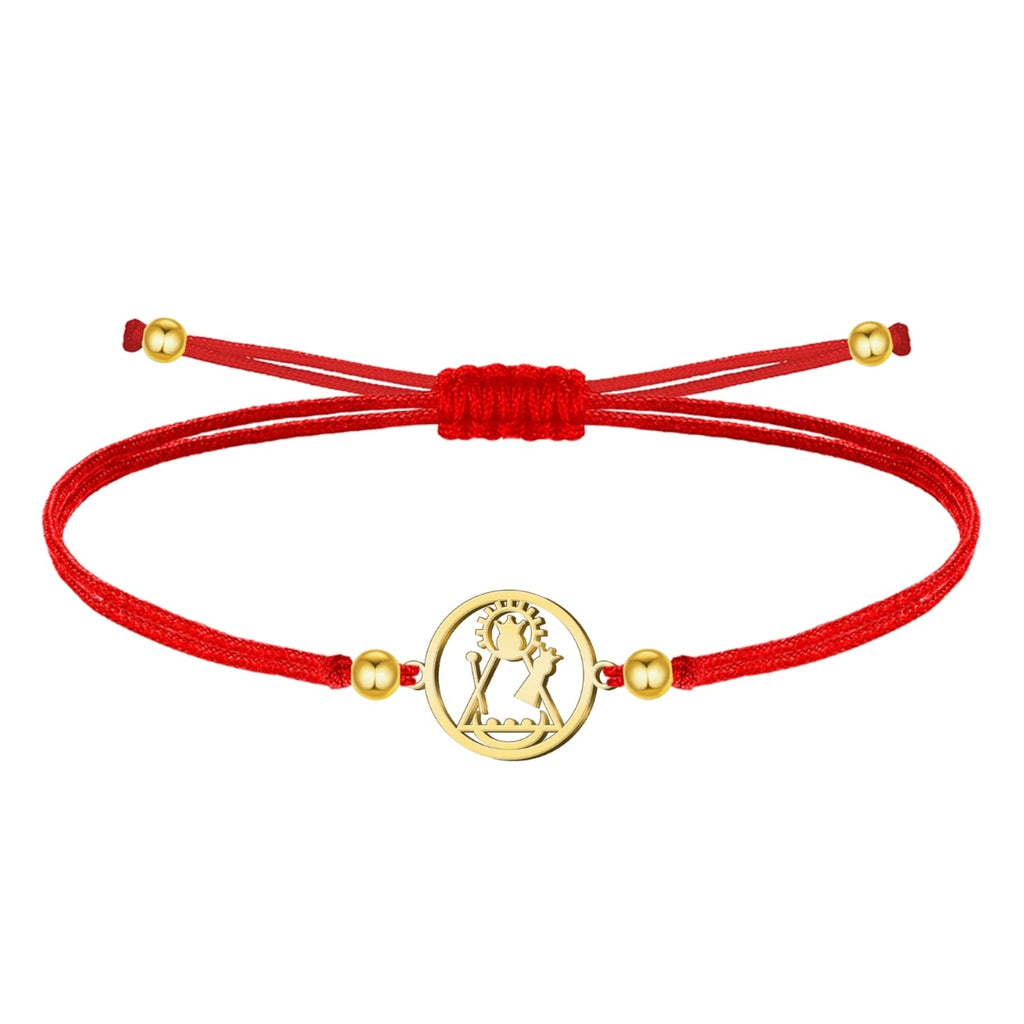 Pulsera de hilo encerado rojo ajustable con medalla central circular de acero inoxidable dorado, mostrando la silueta calada de la Virgen de Candelaria. Detalles de bolitas doradas en los extremos.