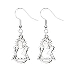 Pendientes de gancho en color plateado con silueta calada de la Virgen de Candelaria, fabricados en acero inoxidable. Diseño moderno con detalles de corona, rayos de sol y media luna.