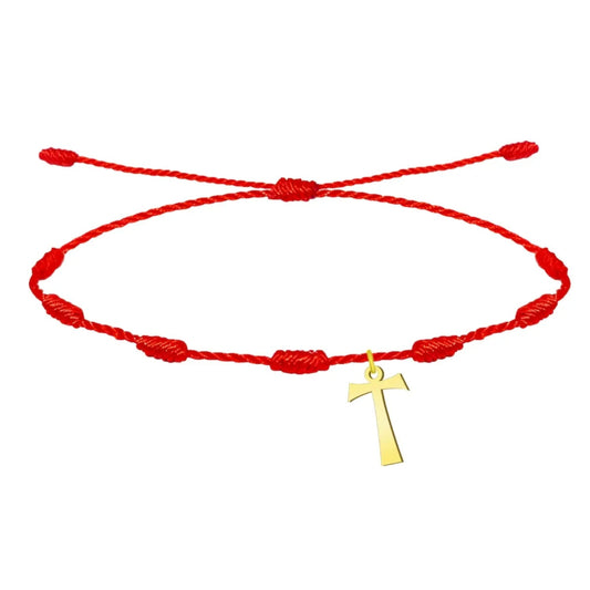 Pulsera de hilo rojo con diseño de 7 nudos de protección, que incluye un dije colgante de la cruz Tau en acero con acabado dorado y cierre ajustable de nudo corredizo.
