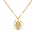Collar de araña dorada con circonitas, detalle del colgante sobre fondo blanco.