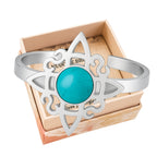 Anillo abierto de acero plateado con diseño de Nudo de Bruja y piedra central de Turquesa azul vibrante.