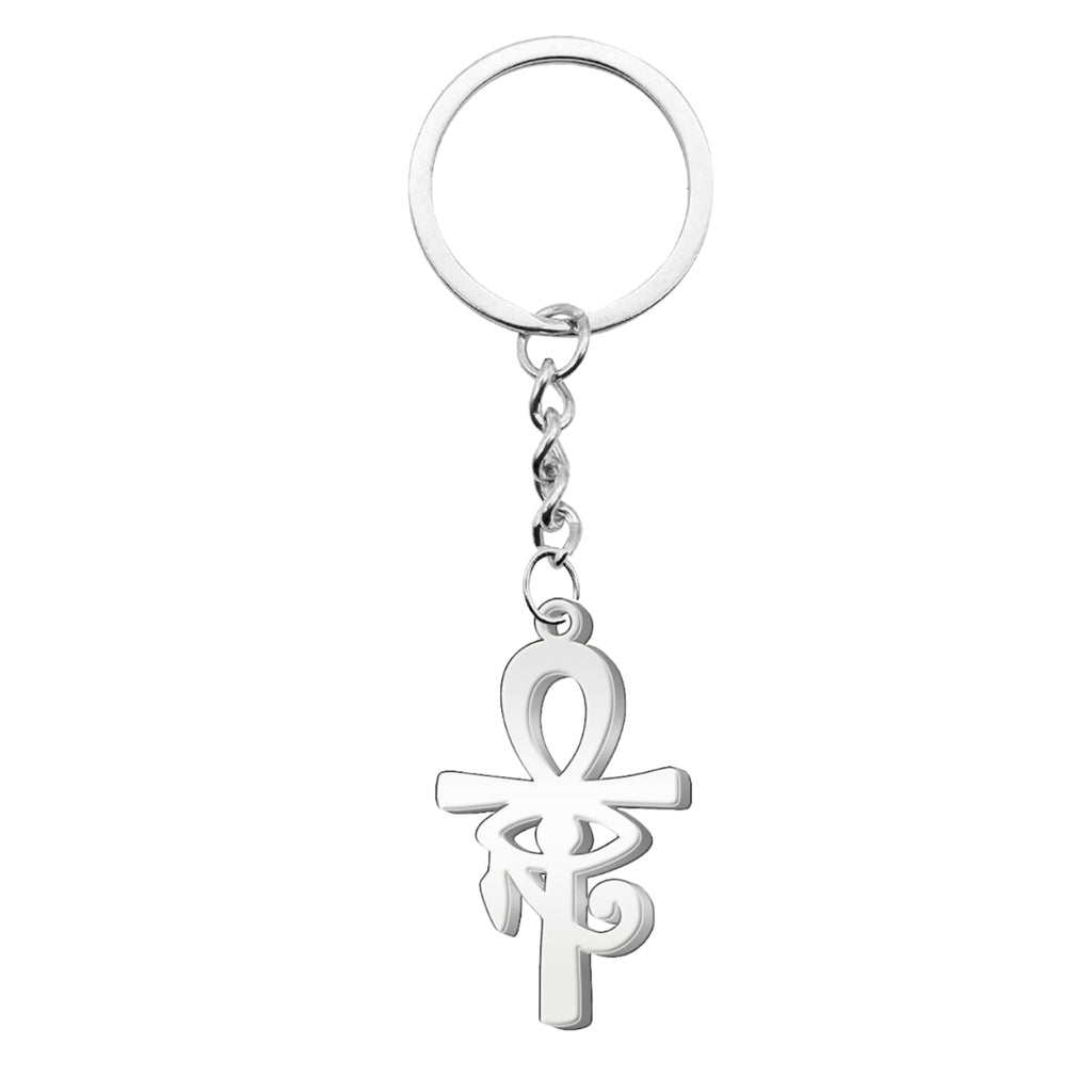 Llavero de acero inoxidable en color plateado que presenta el símbolo de la Cruz Egipcia (Ankh) con el Ojo de Horus integrado en su diseño central, unido a una argolla metálica mediante una cadena de eslabones corta.