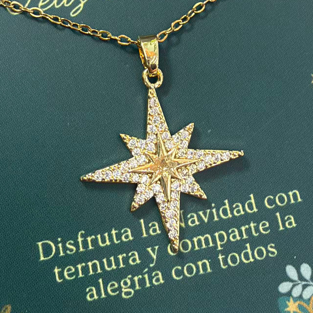 Pormenor do colar de estrela dourada de oito pontas sobre o seu cartão para oferta.