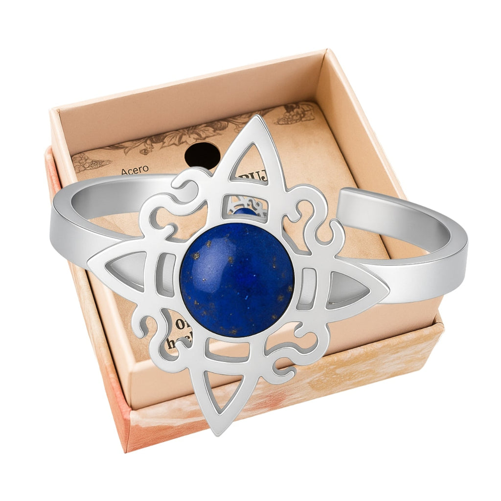 Anillo abierto de acero plateado con diseño de Nudo de Bruja y piedra central de Lapislázuli azul con destellos dorados.