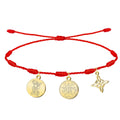 Pulsera de hilo rojo 7 nudos con tres amuletos de acero inoxidable dorado: San Miguel Arcángel venciendo al mal (izquierda), Sello del Tetragramatón (centro) y Nudo de Bruja (derecha).
