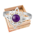Anillo abierto de acero plateado con diseño de Nudo de Bruja y piedra central de Amatista morada.