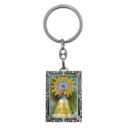 Llavero metálico rectangular con marco plateado ornamentado y una imagen a todo color de la Virgen del Pilar en el centro.