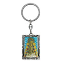 Llavero metálico plateado con marco ornamentado e imagen a todo color de la Virgen del Rocío con fondo de cielo azul