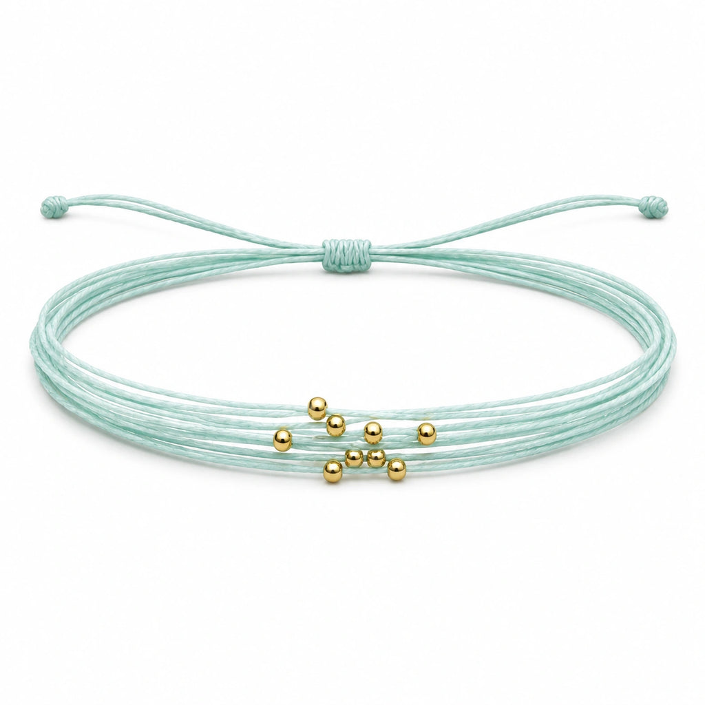 Pulsera Multihilo Encerado con Cuentas de Acero Inoxidable - Azul Cian sobre fondo blanco