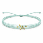Pulsera Multihilo Encerado con Cuentas de Acero Inoxidable - Azul Cian sobre fondo blanco