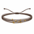 Pulsera Multihilo Encerado con Cuentas de Acero Inoxidable - Marrón sobre fondo blanco