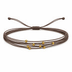 Pulsera Multihilo Encerado con Cuentas de Acero Inoxidable - Marrón sobre fondo blanco