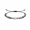 Pulsera de Hilo con Cuentas Heishi y Bola de Acero - Negro sobre fondo blanco