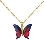 Colar de borboleta em tons cor-de-rosa e azuis, com corpo de tom dourado, sobre fundo branco.
