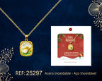 Collar dorado con medallón rectangular de ciervo junto a su tarjeta de regalo, sobre fondo oscuro.