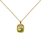 Collar dorado con medallón rectangular de ciervo, vista frontal sobre fondo blanco.