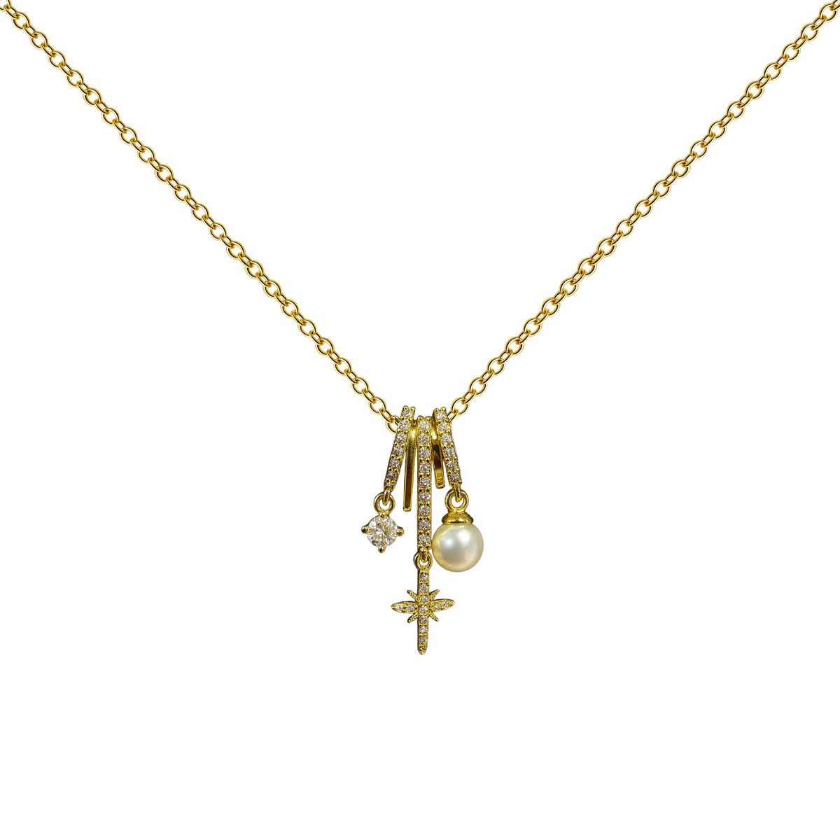 Collar dorado de estrella y esfera clara, con un pequeño detalle brillante, sobre fondo blanco.