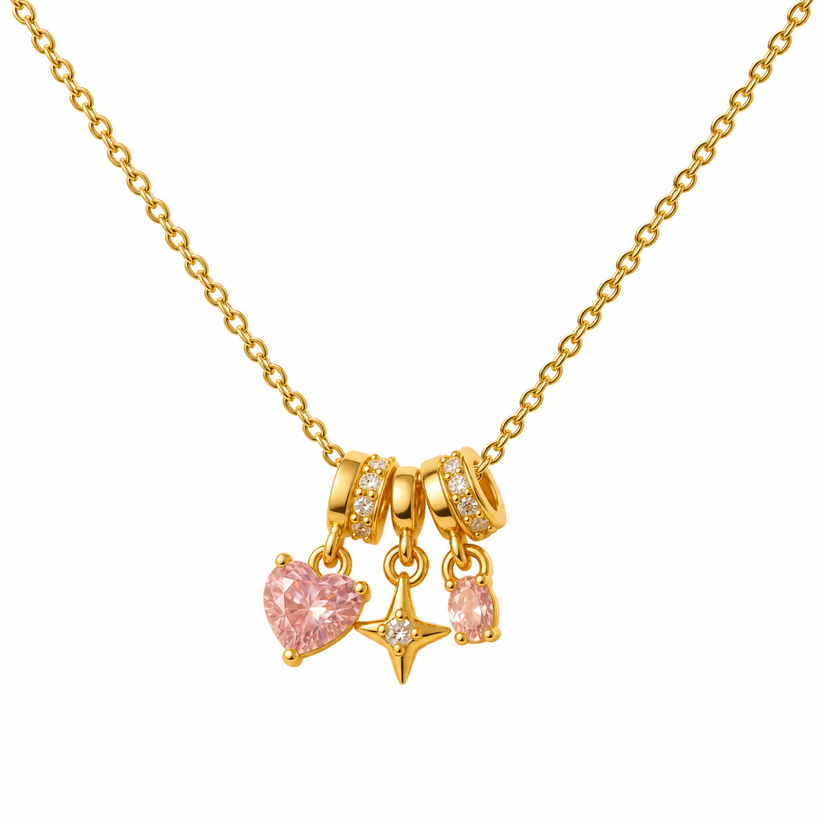 Collar dorado con corazón rosa, estrella y piedra ovalada sobre fondo blanco