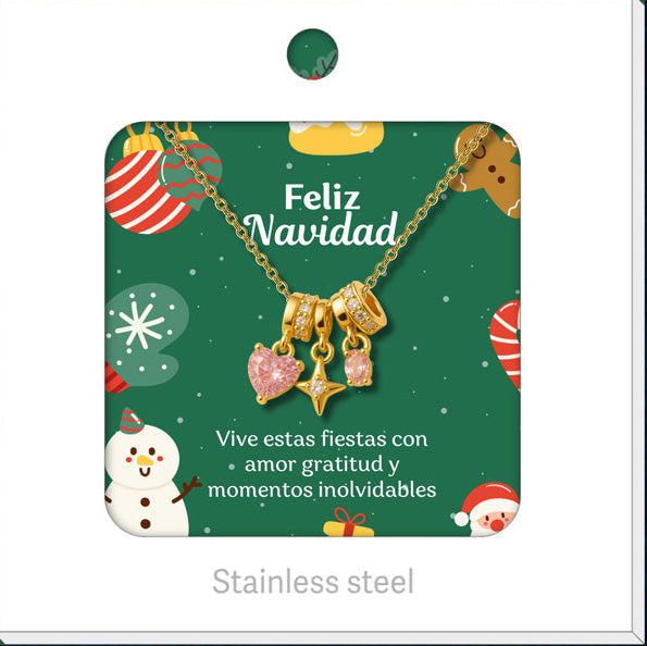 Collar dorado de corazón rosa y estrella, presentado en tarjeta navideña.