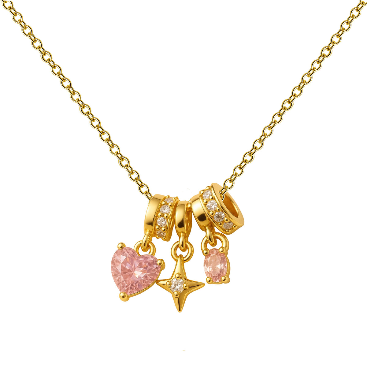 Colar dourado de coração cor-de-rosa e estrela, vista frontal sobre fundo branco.