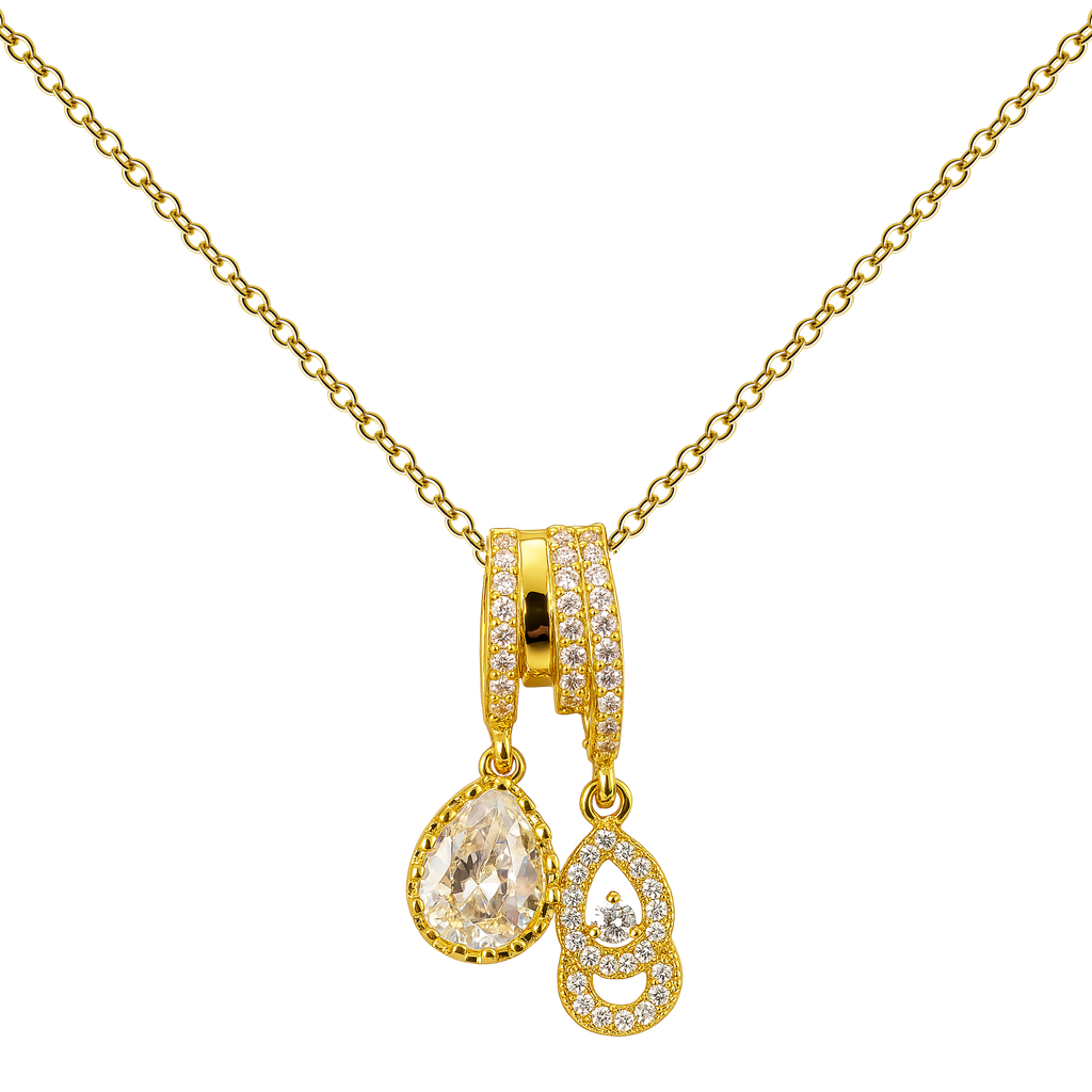 Collar dorado de doble colgante con detalle transparente, con adorno en forma de gota, sobre fondo blanco.
