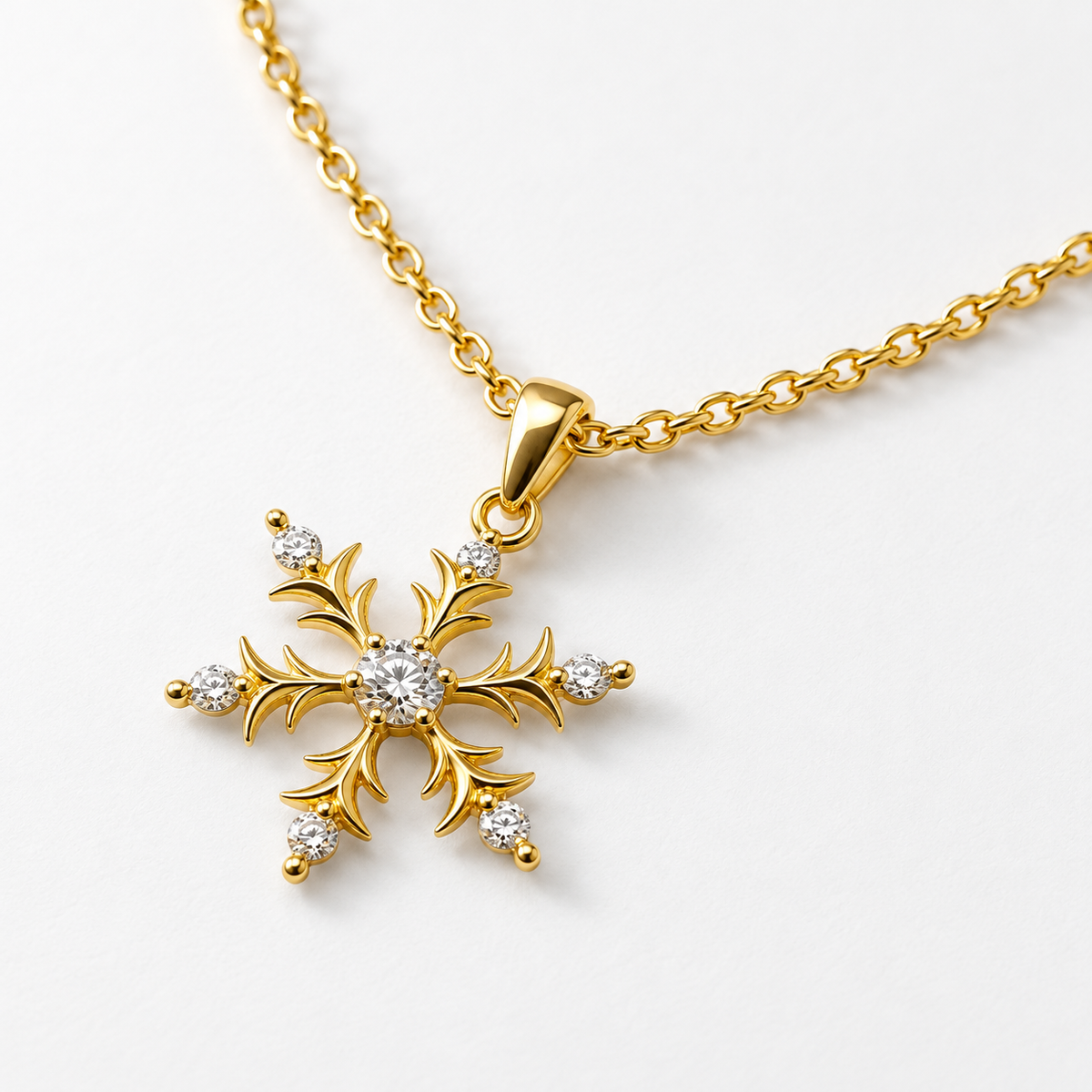 Collar dorado de copo de nieve, detalle sobre una superficie blanca.