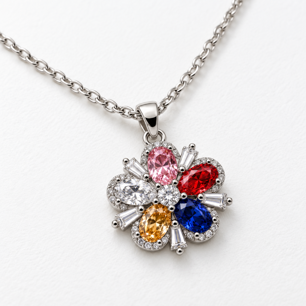 Collar de flor multicolor con circonitas, detalle sobre una superficie blanca.