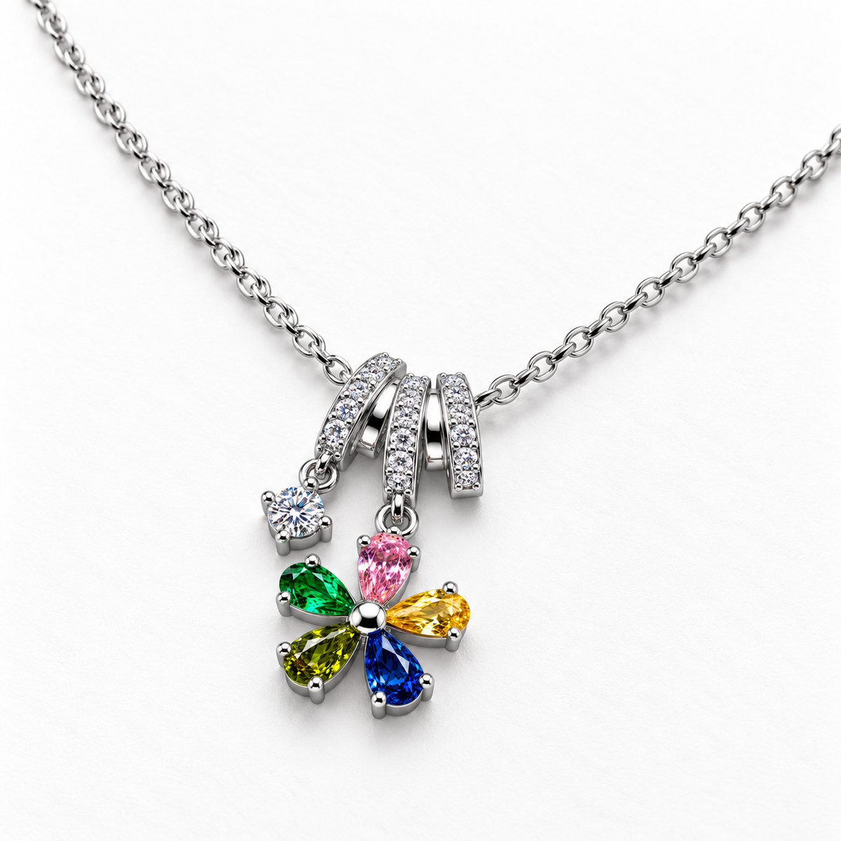 Collar de flor con circonitas de colores, detalle sobre una superficie blanca.