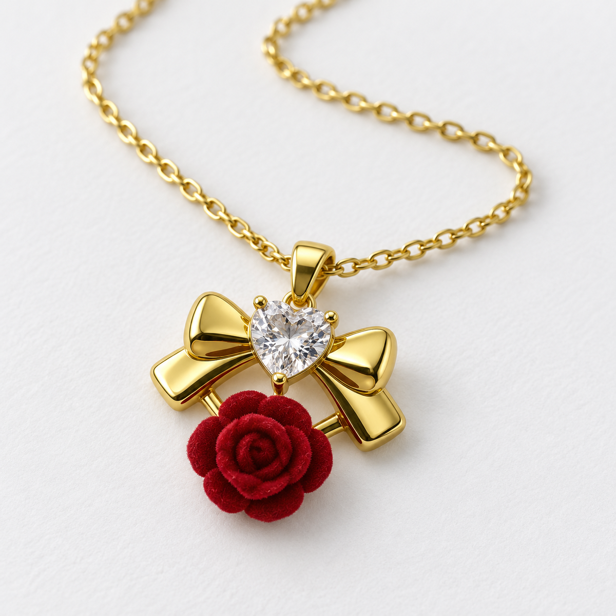 Red Rose and Gold Tone Bow Necklace, viewed at an angle on a white background.