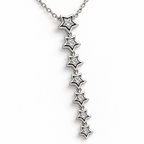 Collar de estrellas colgantes, detalle sobre una superficie blanca.