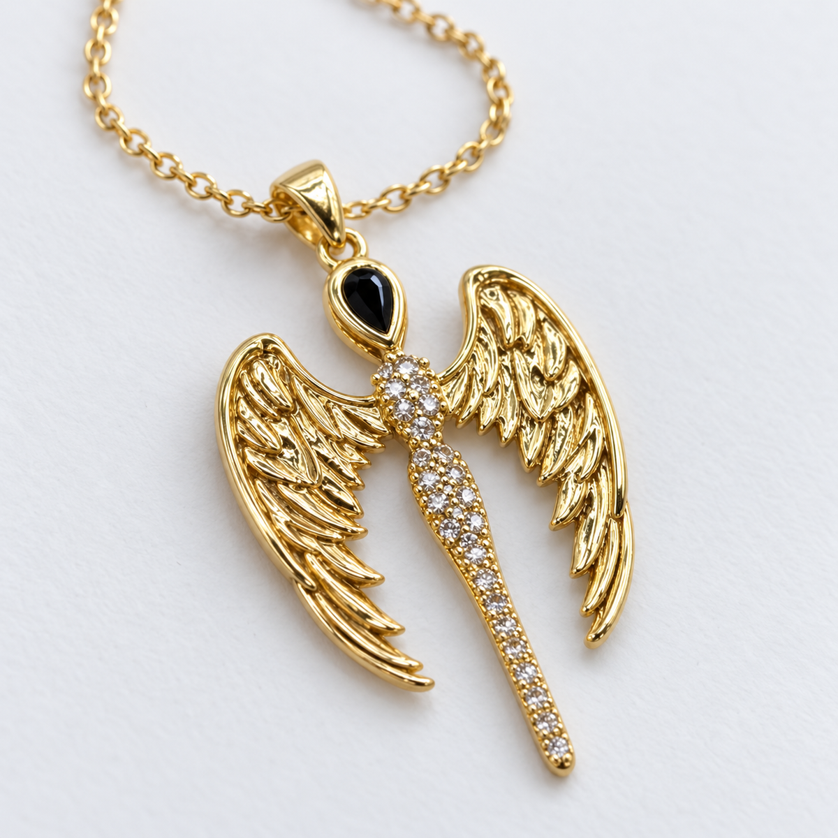 Gold Tone Wing Necklace with Cubic Zirconia, viewed at an angle on a white background.