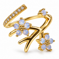 Anillo dorado de flores azules y ramas