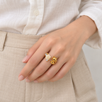 Anillo ajustable dorado de gato y rosa blanca — combinación con ropa; imagen ilustrativa generada con IA, escala no verificada.