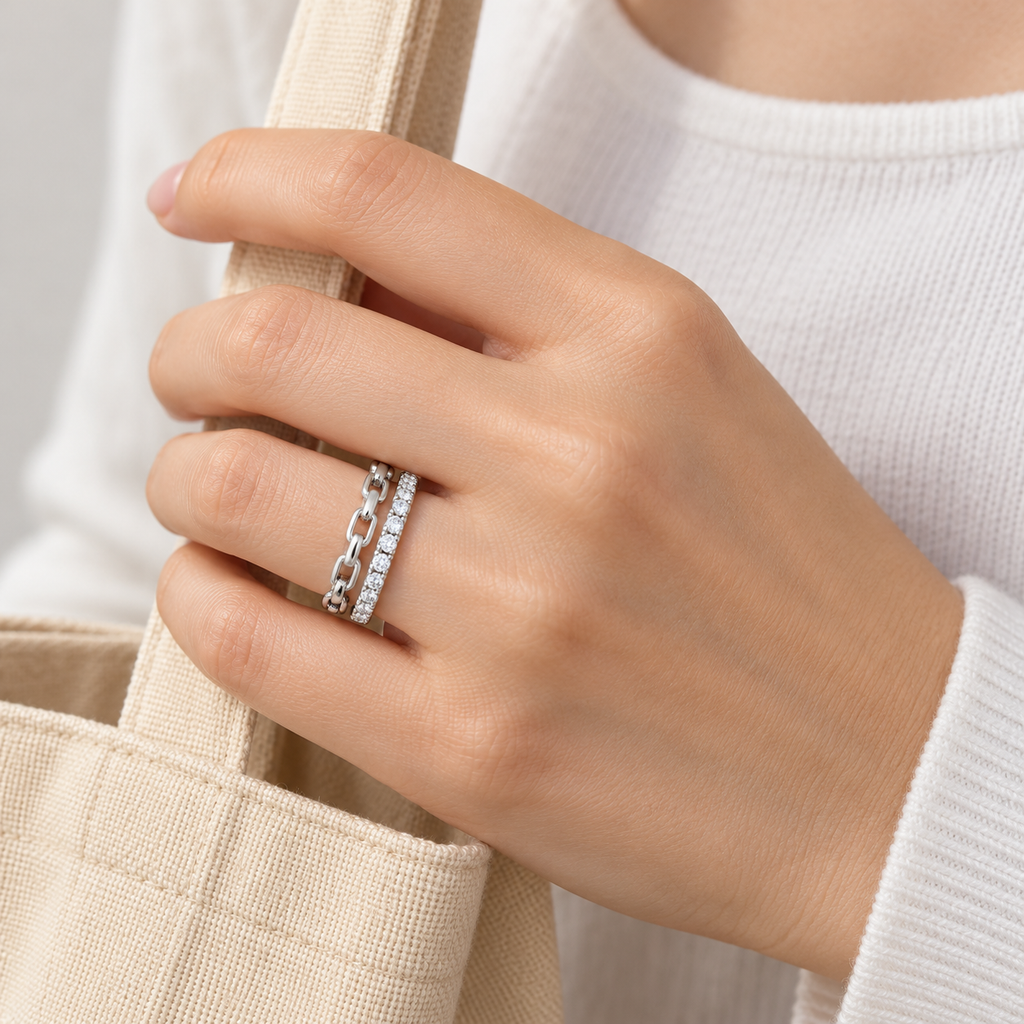 Anillo ajustable plateado de eslabones y doble banda — escena cotidiana; imagen ilustrativa generada con IA, escala no verificada.