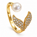 Anillo dorado de alas y esfera blanca
