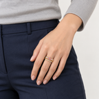 Anillo ajustable dorado de centro rosa y doble banda — combinación con ropa; imagen ilustrativa generada con IA, escala no verificada.